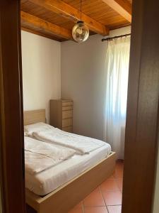 a bedroom with a bed and a window at LI DA BIS Affittacamere in Avasinis