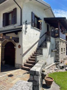 a building with stairs and a door and a porch at LI DA BIS Affittacamere in Avasinis