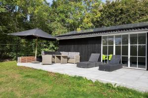 a patio with a table and chairs and an umbrella at LF391-Vestervig-Gunhildsvej-1 in Vestervig