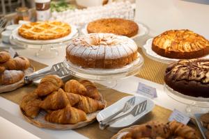 a table with different types of cakes and pastries at Hotel Corallo in Pietra Ligure