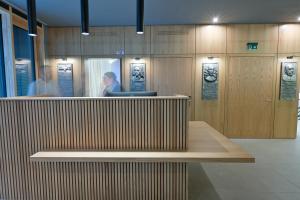 a woman is sitting at a counter in a room at Hotel Spenerhaus - neu und vollklimatisiert in allen Zimmern in Frankfurt