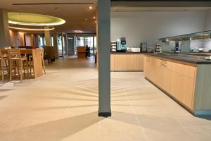 a large kitchen with wooden cabinets and a table at Hotel Spenerhaus - neu und vollklimatisiert in allen Zimmern in Frankfurt +24 photos