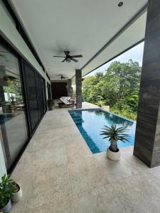 a swimming pool in a house with a ceiling fan at Villa Montemar Ocean and Mountain Views in Platanillo