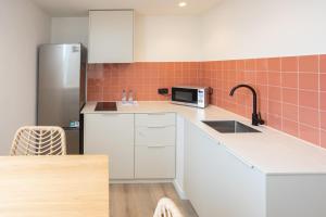a kitchen with a sink and a refrigerator at Apartamentos San Antonio Beach in San Antonio Bay