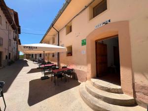 an outdoor patio with tables and chairs and an umbrella at Casa Rural Tronchon in Tronchón
