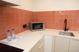 a kitchen with a sink and a microwave at Apartamentos San Antonio Beach in San Antonio Bay
