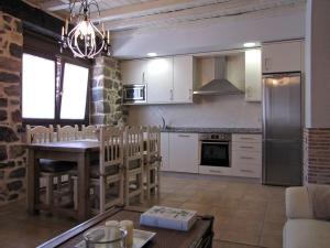a kitchen with a table and a dining room at Casa del Tío Benito 2H in Molinos de Duero