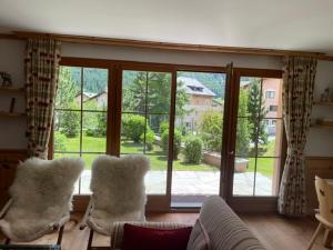 a living room with two chairs and a large window at 2,5 Zimmer Wohnung mit Bergblick in Engadin in Zuoz