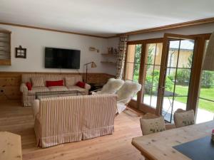 a living room with couches and a flat screen tv at 2,5 Zimmer Wohnung mit Bergblick in Engadin in Zuoz