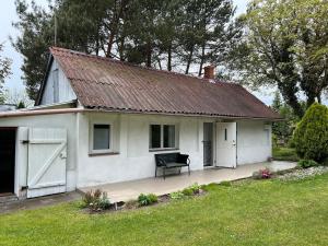 a white house with a bench in front of it at Agroturystyka Uroczysko Kostomłoty in Kostomłoty