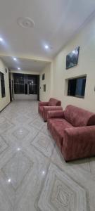 a large living room with a large couch in a room at Anusthan Hotel in Ūnchāhar