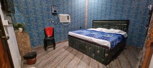 a bedroom with a bed in a room with blue walls at Anusthan Hotel in Ūnchāhar +4 photos
