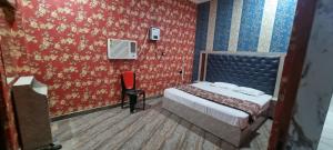 a small bedroom with a bed and a chair at Anusthan Hotel in Ūnchāhar