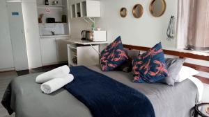a bedroom with a bed with blue and red pillows at Ryans Surf Cabin in Jeffreys Bay