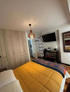 a bedroom with a large bed with a yellow blanket at HOSPEDAJE HUIT STAr in Buenos Aires
