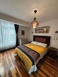 a bedroom with a large bed and a chandelier at HOSPEDAJE HUIT STAr in Buenos Aires