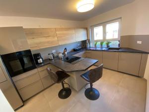 a kitchen with a counter and two bar stools at TLA-A-K83a in Bruchmühlbach-Miesau
