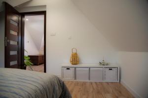 a bedroom with a bed and a white wall at Pod Lwią Górą in Strużnica