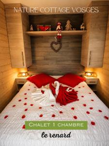a woman laying on a bed covered in red hearts at Nature Cottage Vosges in Anould