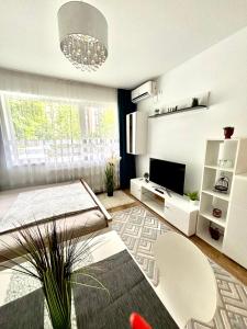 a living room with a chandelier and a table and chairs at Kiki home in Oradea