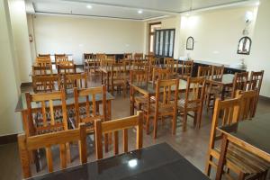 a room filled with tables and wooden chairs at The Kalindi's Resort, Almora in Almora