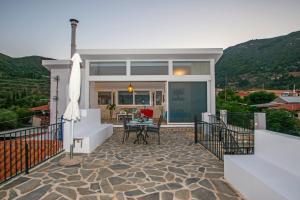 a house with a patio with a table and chairs at Dream View Loft in Lithakia