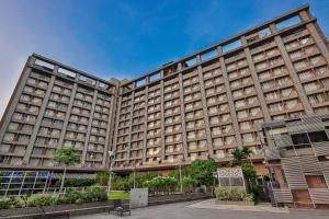 a large building with many windows on it at Weekend Address By Farmville in Surat
