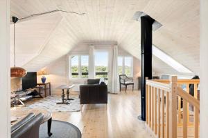 a living room with a vaulted ceiling and a staircase at LF15156-Hojslev-Mosevej-156 in Højslev