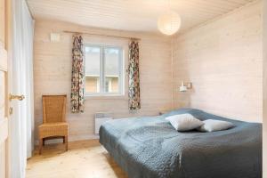 a bedroom with a bed and a chair and a window at LF15156-Hojslev-Mosevej-156 in Højslev