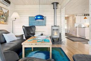 a living room with a couch and a table and a fireplace at LF15156-Hojslev-Mosevej-156 in Højslev +26 photos