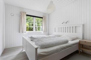 a bed in a white room with a window at LF16310-Nibe-Alerusen-97 in Nibe