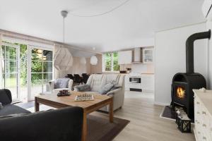 a living room with a couch and a fireplace at LF16310-Nibe-Alerusen-97 in Nibe