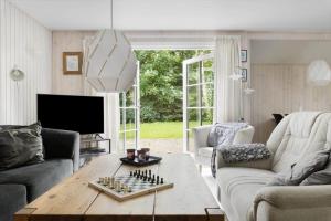 a living room with a chessboard on a wooden table at LF16310-Nibe-Alerusen-97 in Nibe