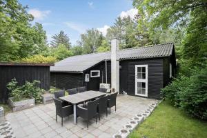 a patio with a table and chairs in front of a house at LF16310-Nibe-Alerusen-97 in Nibe