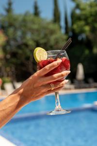 a woman holding a drink with a lime slice on it at Hotel ROC Oberoy - Adults Only in Paguera