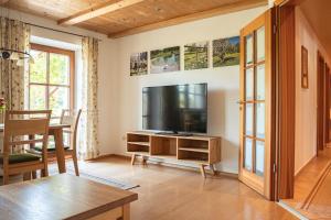 a living room with a television and a table at Holzhauser Hof in Waldkraiburg