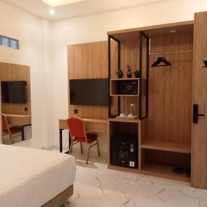 a hotel room with a bed and a desk and a television at NH Residence Yogyakarta in Ngabean