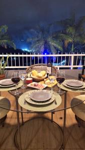 a table with plates and wine glasses on a balcony at Aconchegante stúdio com varanda in Bananeiras +18 photos