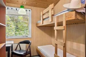 a bunk bed in a tiny house with a chair at LF15191-Hojslev-Ternevej-31 in Højslev