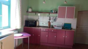 a kitchen with red cabinets and a microwave at Bülitz33 in Luckau