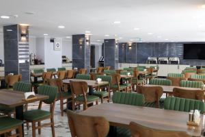 a restaurant with wooden tables and green chairs at Zelif Otel Havza in Havza