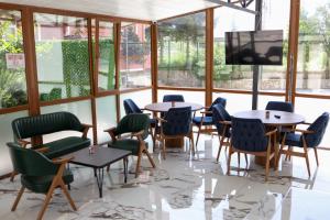 a room with tables and chairs and a flat screen tv at Zelif Otel Havza in Havza