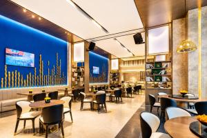 a restaurant with tables and chairs and a blue wall at Tian Yi International Hotel 天艺国际酒店 in Phnom Penh