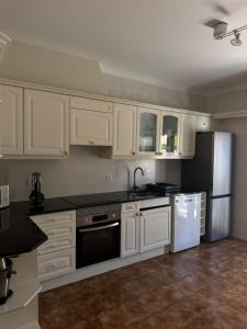 a kitchen with white cabinets and a refrigerator at Three Sisters in Altura