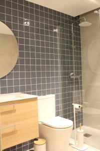 a blue tiled bathroom with a toilet and a shower at Three Sisters in Altura +6 photos