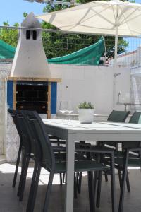 a white table with chairs and an outdoor fireplace at Three Sisters in Altura