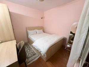 a small bedroom with a bed with white sheets at Lux Apartment in Kathmandu