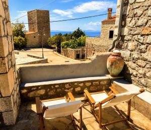 two chairs and a vase sitting on a balcony at Diaks Tower Sunset Sea View Mani in Pyrgos Dirou