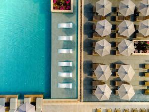 a wall with umbrellas next to a pool at Iolida Corfu Resort by Smile Hotels in Dassia