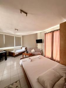a bedroom with two beds and a living room at Alpha apartment 21 in Serres